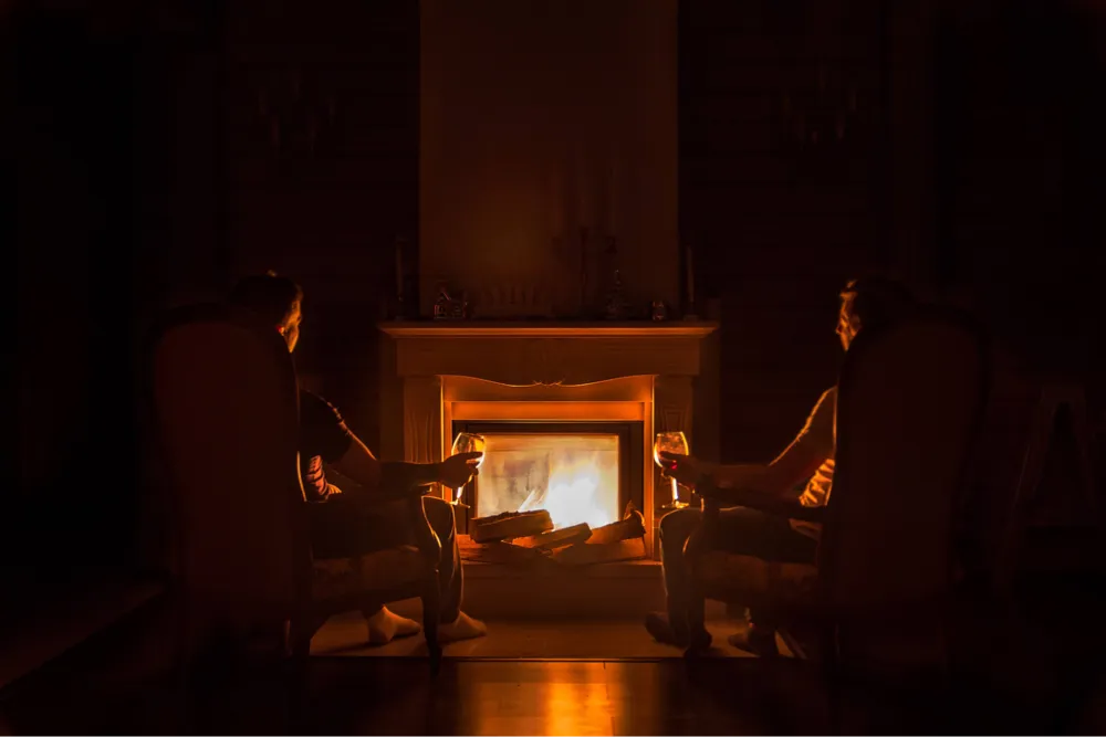 Drinking a glass of wine by the fireplace with loved ones (Photo: Sergei Solo, Unsplash.com)